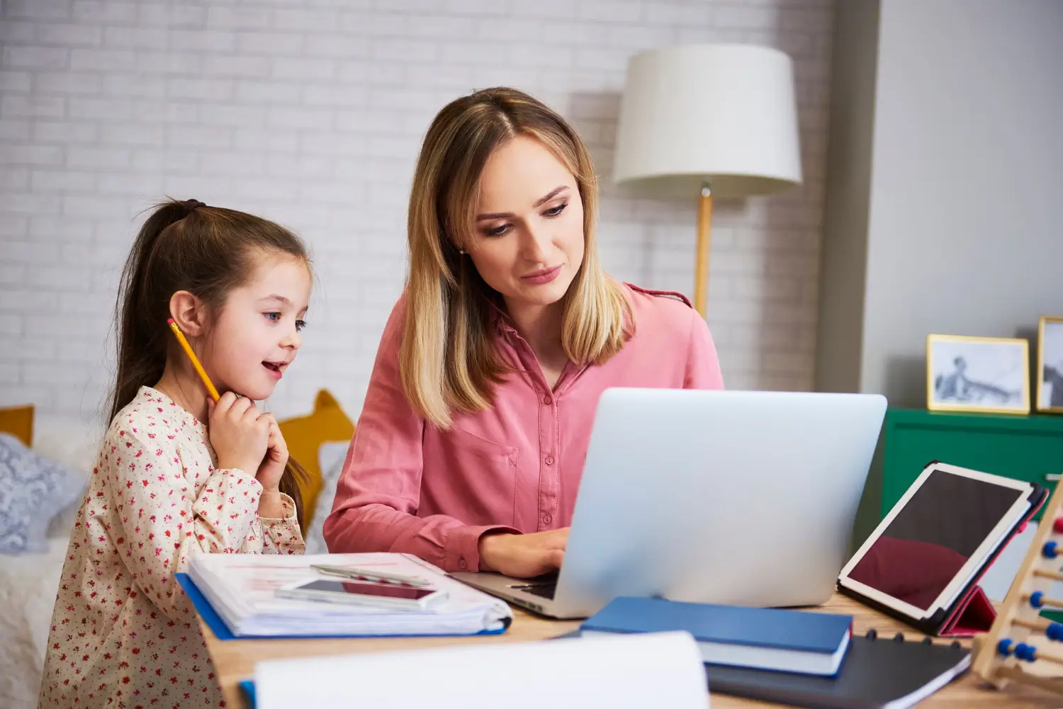 Female IB tutor teaching reading and math to a primary school student in a home setting