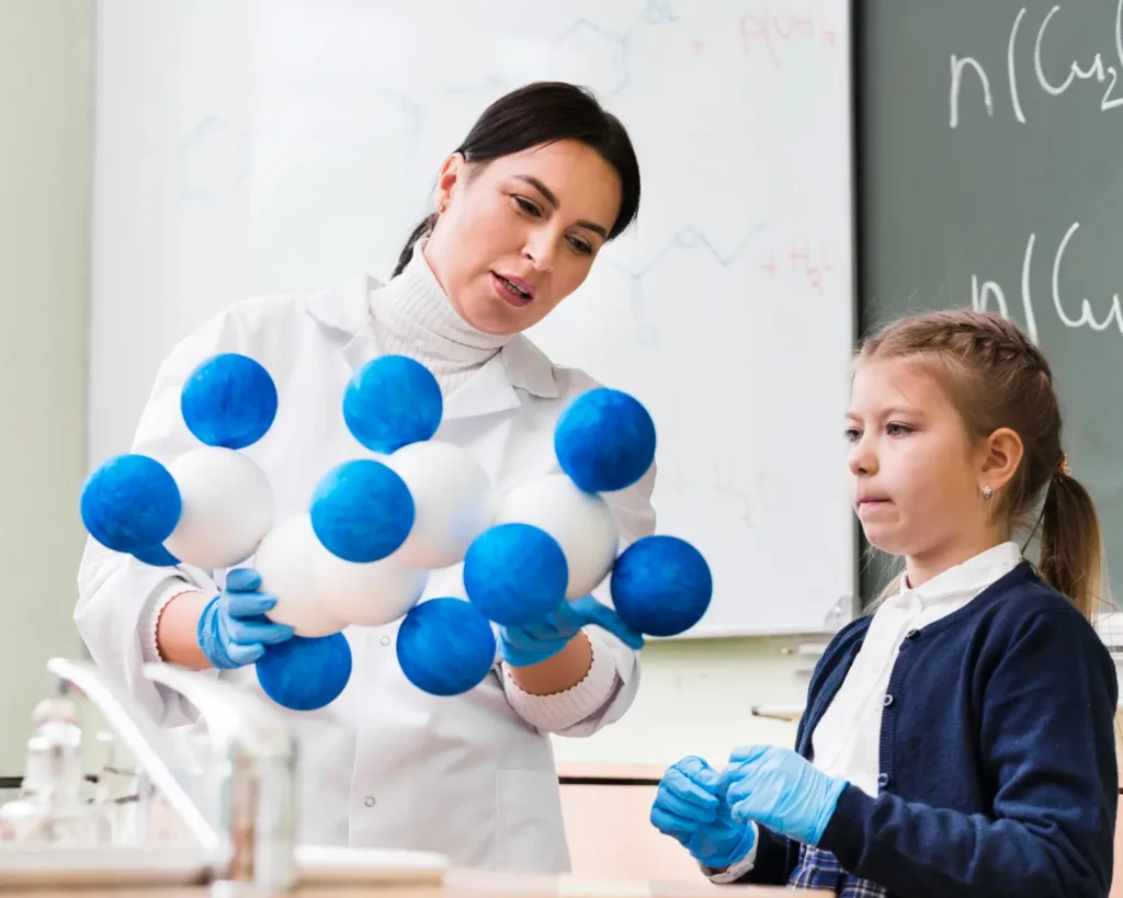 Chemistry tutor at home teaching junior kid vital lessons with her chemical models