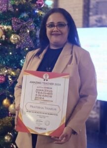 Ms. Pratibha Thakur, a school teacher in Dubai, proudly holding her 'Amazing Teacher Awards 2024' certificate.