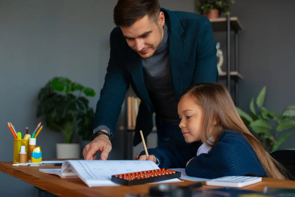 Professional calculus tutor in Dubai explaining derivative concepts to student during private home tutoring session with mathematical equations on whiteboard